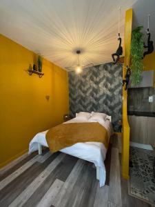伊泽尔河畔的罗曼JuNgLe ROOM的一间卧室设有一张黄色墙壁的大床