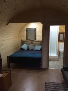 卡莱尔Broomhills Farm River Eco Pods的木制客房内的一间卧室,配有一张床