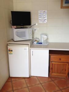 黄金海岸旭日汽车旅馆的一间带微波炉和冰箱的小厨房