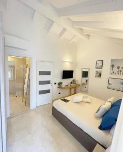奥尔比亚Corso Umberto Rooms的白色卧室设有一张大床和电视。