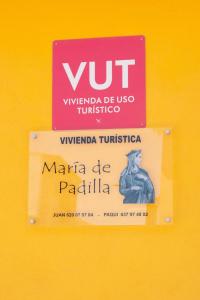 MontielVivienda turística María de Padilla的黄色墙上的标志,带有Vnt标志