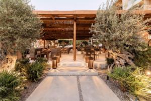 林都斯Lindos Aqua Terra的户外餐厅设有桌椅和树木
