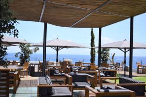 丰沙尔Madeira Regency Cliff - Adults Only的一间带桌椅和遮阳伞的餐厅