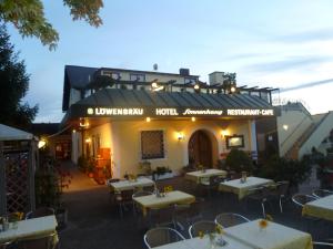登肯多夫Hotel Gasthof Sonnenhang的大楼前设有桌椅的餐厅