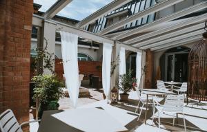 雷吉奥洛Hotel Cavallo Bianco的一座配有白色桌椅的庭院和一座建筑