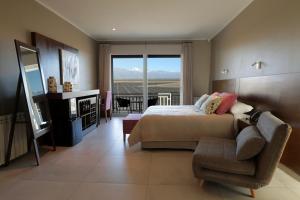 图蓬加托火山Gaia Lodge的卧室配有床、椅子和窗户。