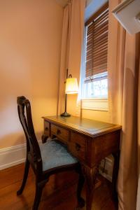 刘易斯堡Thomas Rose Inn的一张桌子,旁边是一盏灯和一把椅子