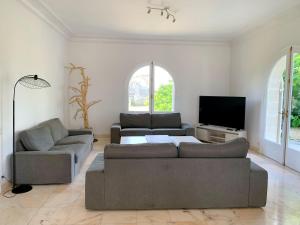 卡斯泰勒雅卢Magnifique villa de charme avec piscine的客厅配有2张沙发和1台平面电视