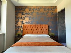 夸利亚诺Ninfa hotel的一间卧室配有一张带橙色床头板的床