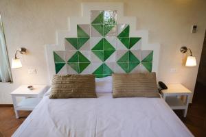 斯克佩罗Casale La Macina - Hotel, Scopello的卧室配有一张白色床和几何床头板