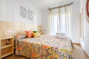 哈卡OTAL URBAN de "Casa Otal"的一间卧室配有一张带彩色床罩的床