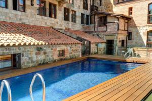 苏安塞斯哥斯达黎加埃斯梅拉达套房酒店的一座游泳池,旁边是一座木甲板