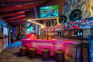 苏安塞斯哥斯达黎加埃斯梅拉达套房酒店的一个带粉色柜台和凳子的酒吧