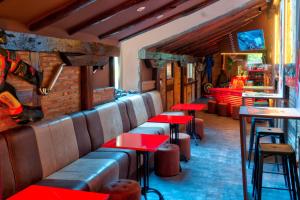 苏安塞斯哥斯达黎加埃斯梅拉达套房酒店的一间设有红色桌子的餐厅和一间酒吧