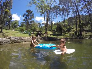 维奥康德马奥Gran Camping Cabanas da Fazenda的两个孩子在河里玩耍
