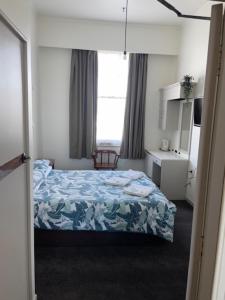 旺阿雷Grand Hotel - Whangarei的一间小卧室,配有床和窗户