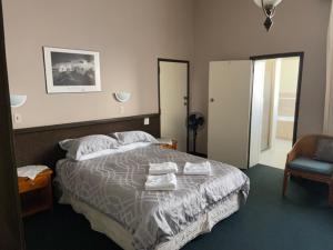 旺阿雷Grand Hotel - Whangarei的一间卧室配有带毛巾的床