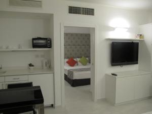 特拉维夫贝斯特韦斯特丽晶套房酒店的客房设有带一张床和电视的卧室。