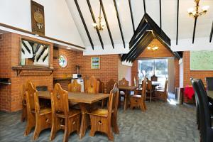 旺加拉塔园景汽车旅馆的用餐室配有木桌和椅子