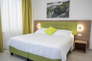 索伦托Casa Marino的一间卧室配有一张大床和绿色床头板