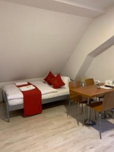 弗兰季谢克矿泉镇Pension VIDHOUS 2的卧室配有1张床、1张桌子和1张桌子以及椅子。