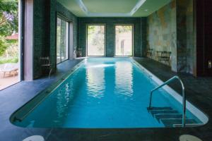 哈维亚Hotel Ritual de Terra & SPA的一座带大窗户的房屋内的游泳池
