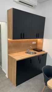 斯玛杰克托莱塞Simba Apartment B的厨房配有水槽和黑色橱柜
