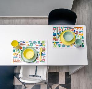 沃洛斯Salina Premium Residences Volos的一张带椅子的白色桌子和两个盘子