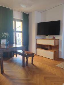 德累斯顿Modernes Apartment an der Frauenkirche的客厅配有桌子和平面电视。