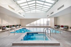 多哈Jouri a Murwab hotel Doha的一座带大型天窗的建筑中的游泳池
