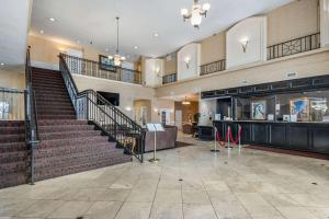克利尔沃特Clarion Inn & Suites Central Clearwater Beach的一个大的大堂,设有楼梯和商店
