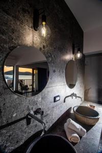 伊罗达Kalypso Suites Hotel - Adults Only的一间带水槽和镜子的浴室