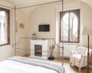 加比亚诺盖比亚诺城堡酒店的一间卧室设有四柱床和一个壁炉