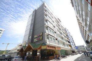 芭东海滩The Patong Center Hotel的一座高大的建筑,前面有一间餐厅