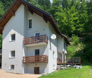 KirchbachFerienwohnung Unsere Mühle的白色的大建筑,设有木制阳台