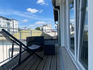 莱比锡LIVING Apartments Leipzig的享有大楼景致的阳台上的椅子