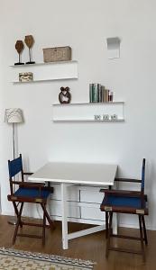 科佩尔蒂诺n°21 (Casa di Anna)的客房内的一张白色桌子和两把椅子