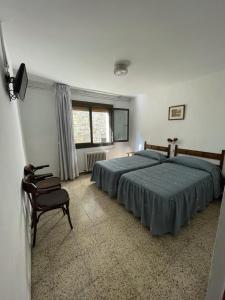塞特卡萨斯Hostal Ter的一间卧室配有两张床和椅子
