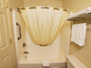 麦卡莱斯特Candlelight Inn & Suites Hwy 69 near McAlester的一间带卫生间和淋浴帘的浴室