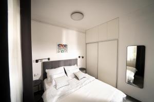 里耶卡Amalis的卧室配有白色的床和镜子