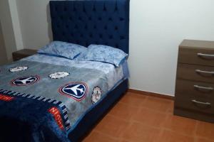利马Hermoso departamento en chorrillos的一间卧室配有蓝色的床和蓝色床头板