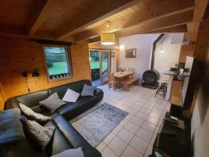 里雾诗Chalet Tontine, 3 bedrooms, sauna, terrace and great views !的客厅配有黑色沙发和桌子