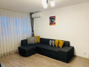 布加勒斯特Apartament Cristina的客厅配有带黄色枕头的黑色沙发