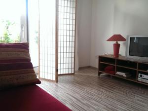 布尔根兰州圣马尔加勒滕Ferienappartement in St. Margarethen的客厅配有电视和带台灯的桌子