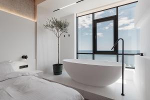 敖德萨Sea and Sky Apartment的白色的浴室设有浴缸和窗户。