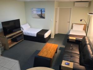 派西亚Bay of Islands Gateway Motel & Apartments的酒店客房,设有两张床和一张沙发