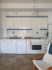 克莉丝蒂娜岛Apartamento en Isla Cristina Puerto Deportivo的厨房配有白色橱柜、水槽和沙发。