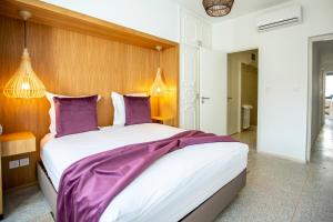 拉巴特Balima Minaret Suites的一间卧室配有一张带紫色床单的大床