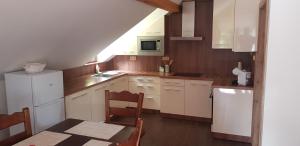 科热诺夫Apartmán Jizerka的厨房配有白色橱柜和桌椅