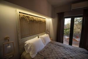 纳夫普利翁Kanathos Pigi的卧室配有带白色枕头的床和窗户。